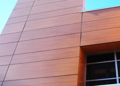 Architectural metal panels with wood-grain finish used in a modern commercial structure, showcasing precision fabrication and durability.