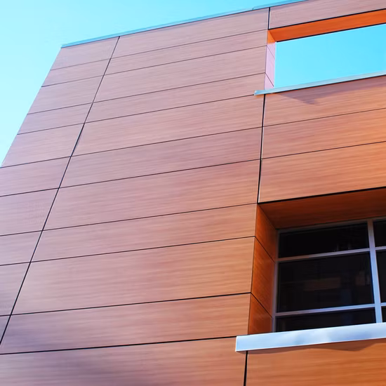 Architectural metal panels with wood-grain finish used in a modern commercial structure, showcasing precision fabrication and durability.